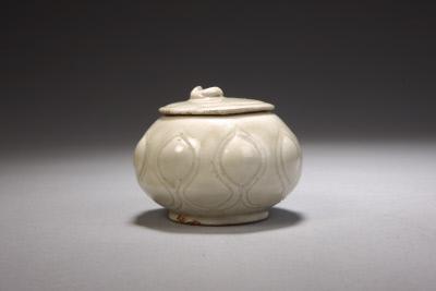 定窑白釉刻划花莲瓣纹“官”字款盖罐,五代,高6.7cm,口径5cm,足径4.9cm。故宫博物院藏。